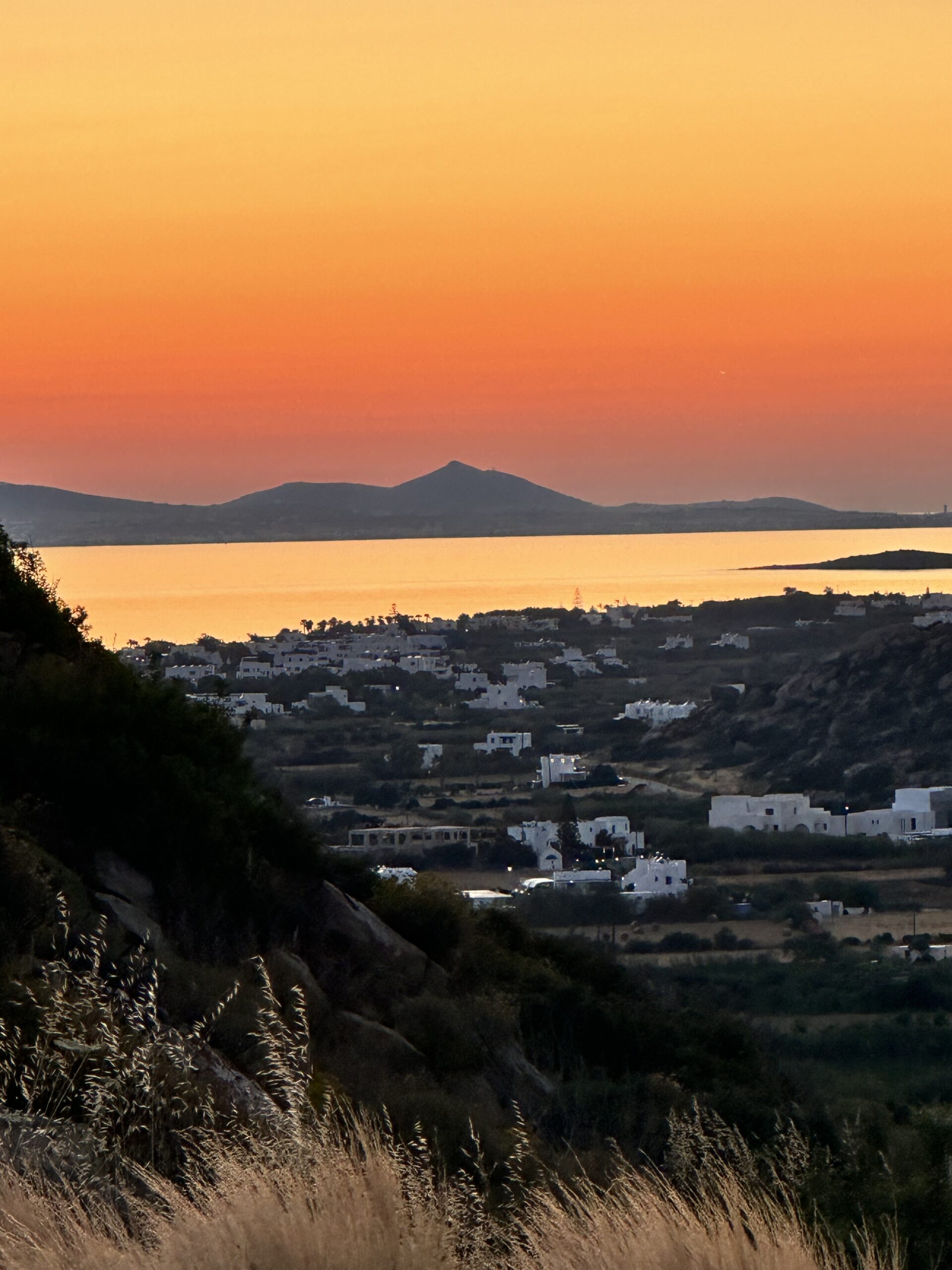 „Sonnenuntergang auf Naxos: Ein atemberaubender Blick auf den goldenen Himmel und das ruhige Meer bei Sonnenuntergang auf der griechischen Insel Naxos. Die warmen Farben des Himmels spiegeln sich im Wasser wider, was die idyllische Schönheit des Ortes unterstreicht.“